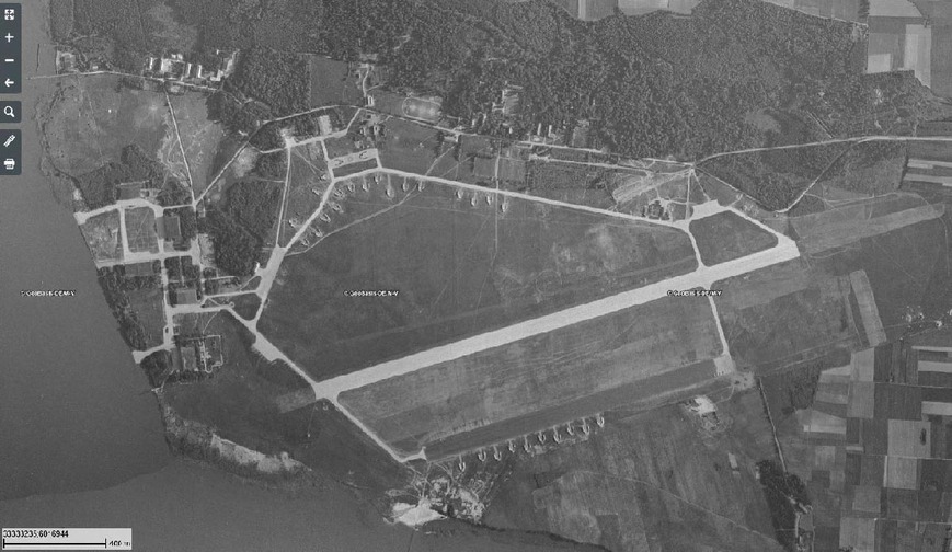 Abb. 2. Luftbild des sowjetischen Militärflugplatzes 1953 mit der neuen Start- und Landebahn zwischen der deutschen Piste im Süden (dunkel) und dem nördlichen Abschluss der Ringrollbahn. Nördlich und südlich befinden sich Splitterboxen. 