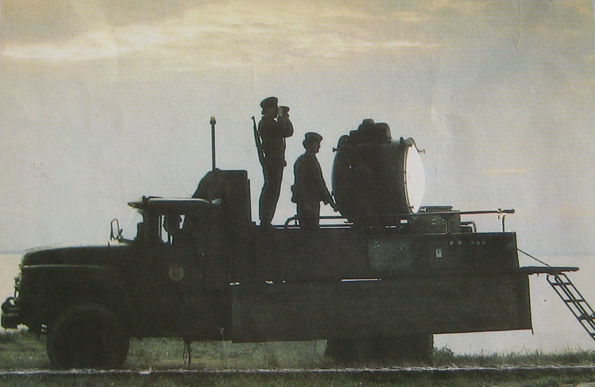 Mobile Scheinwerferstellung, um 1980:  russisches Militärfahrzeug Typ SIL 130 mit zwei Soldaten und einem großen Suchscheinwerfer